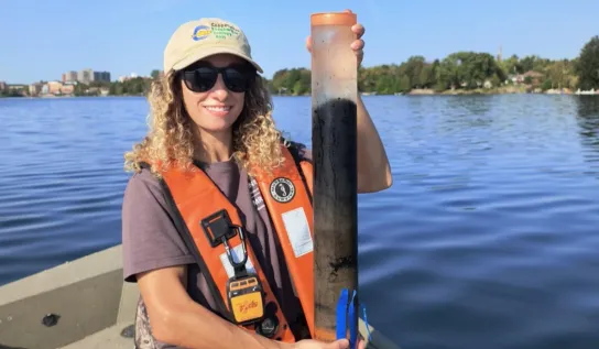 Elizabeth Favot holding a sediment core on a boat