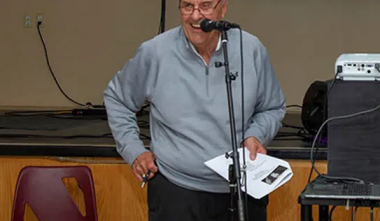 Gary J. Michalak talking through a microphone