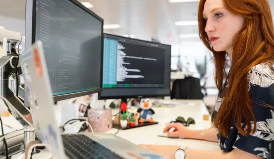 Une étudiante travaillant sur son ordinateur à un bureau 