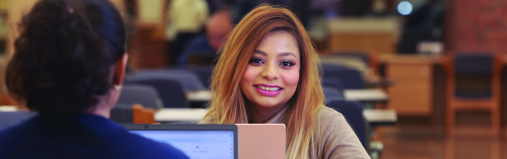 A Laurentian University student on her laptop in the J.N. Desmarais library.