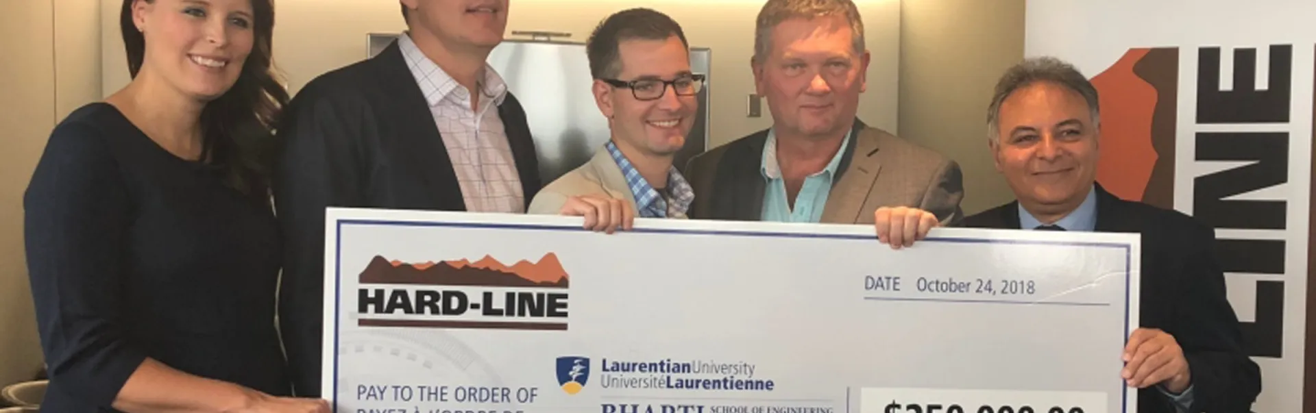 A group of 5 people holding a large $250,000 cheque to the Laurentian University Bharti School of Engineering.