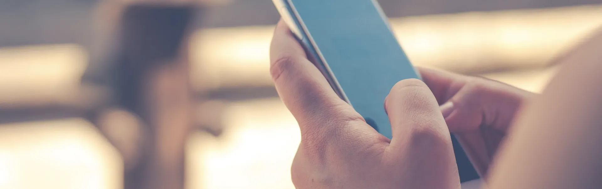 Hands holding a cell phone.