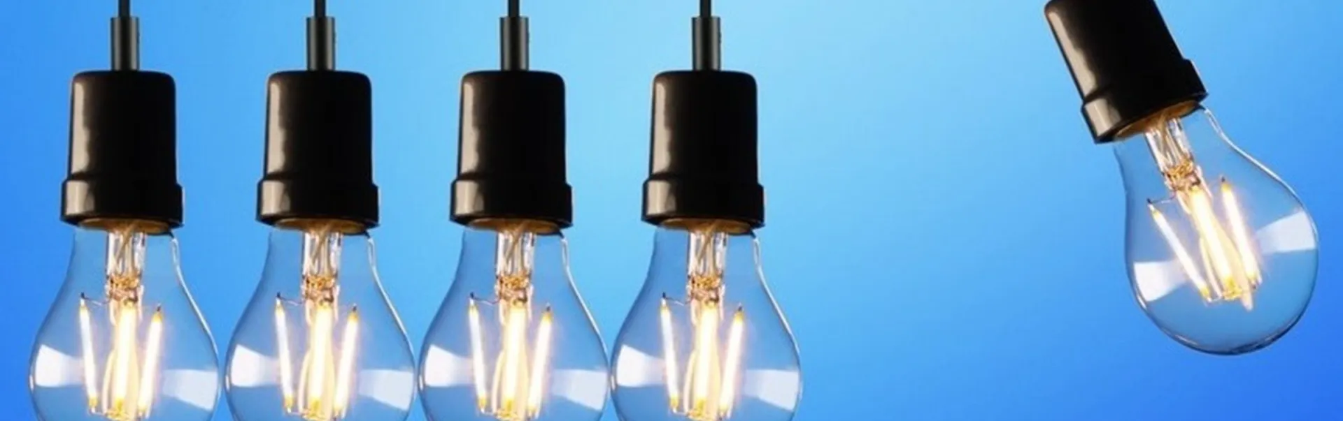 Lightbulbs hanging in front of a blue background.