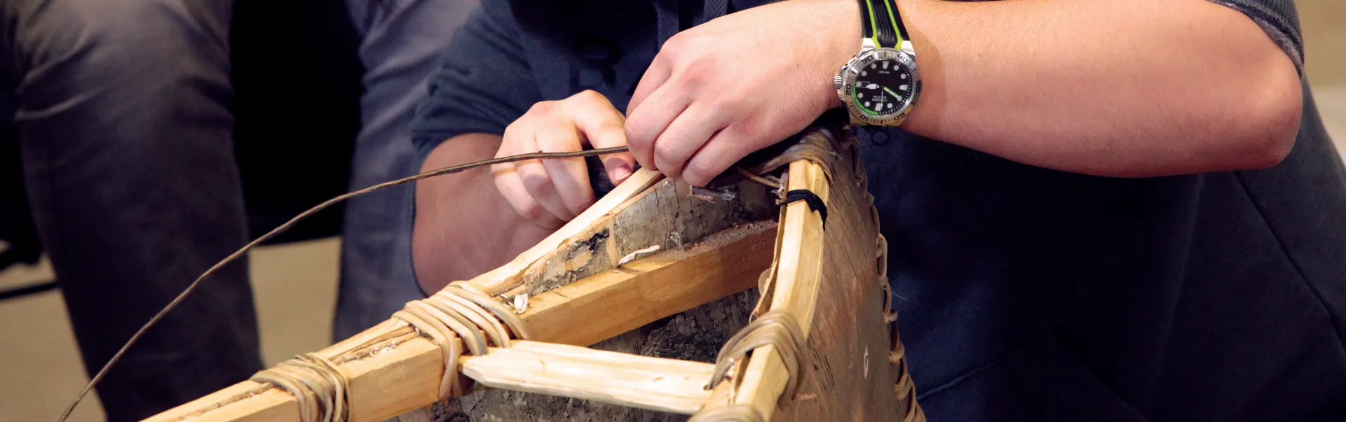 A Laurentian University student building a canoe.