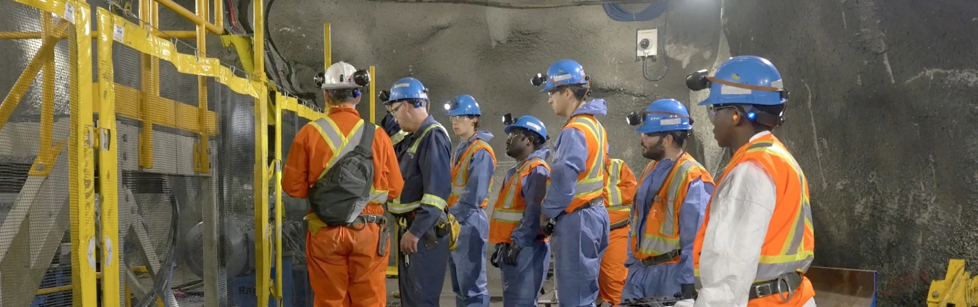 Students in a mine, wearing hard hats