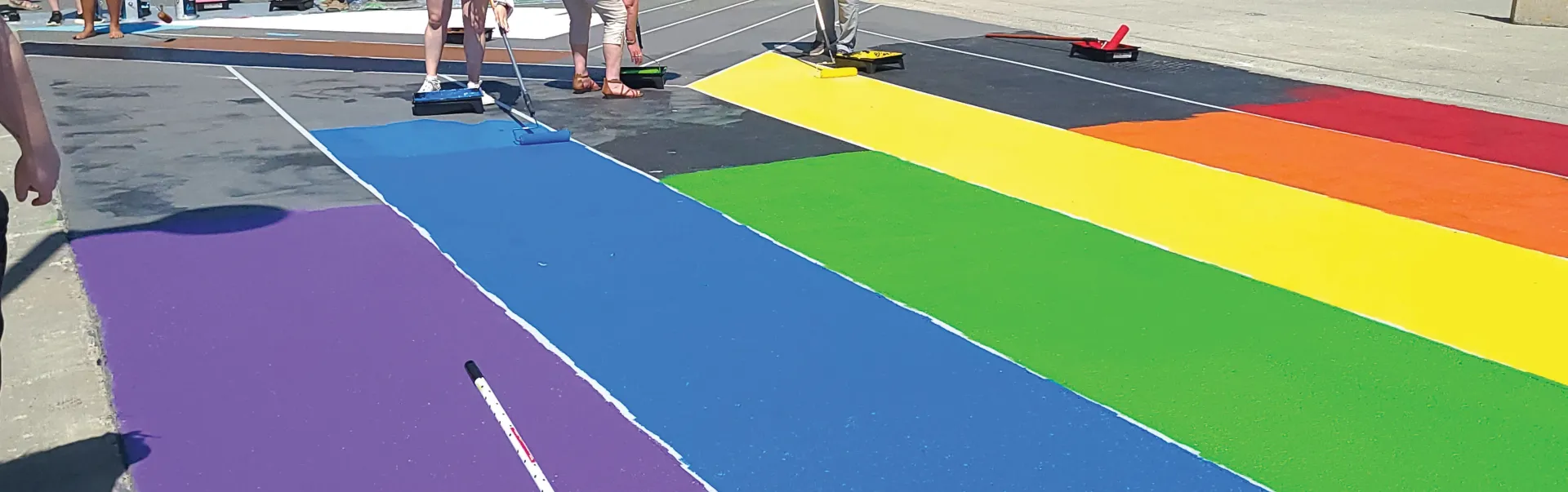 Students helpign paint the Pride Crosswalk
