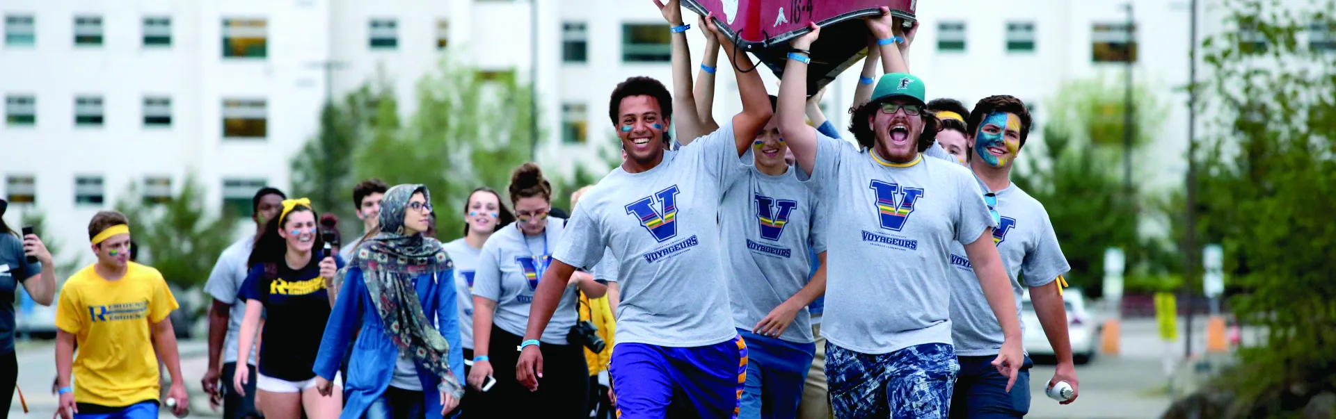 Laurentian students holding a canoe in the air, going to orientation activities.