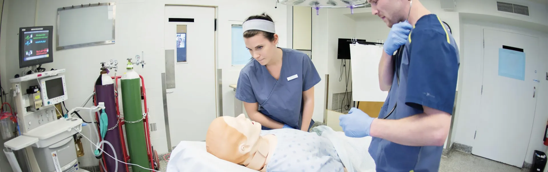 Deux étudiants en Sciences infirmières s'entraînent avec un mannequin médical
