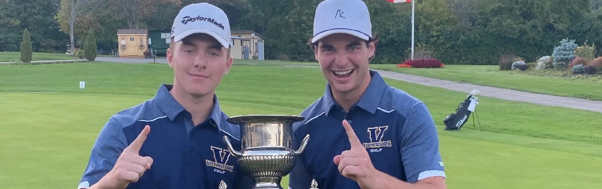 Alex est avec son frère tenant un trophée sur un terrain de golf.