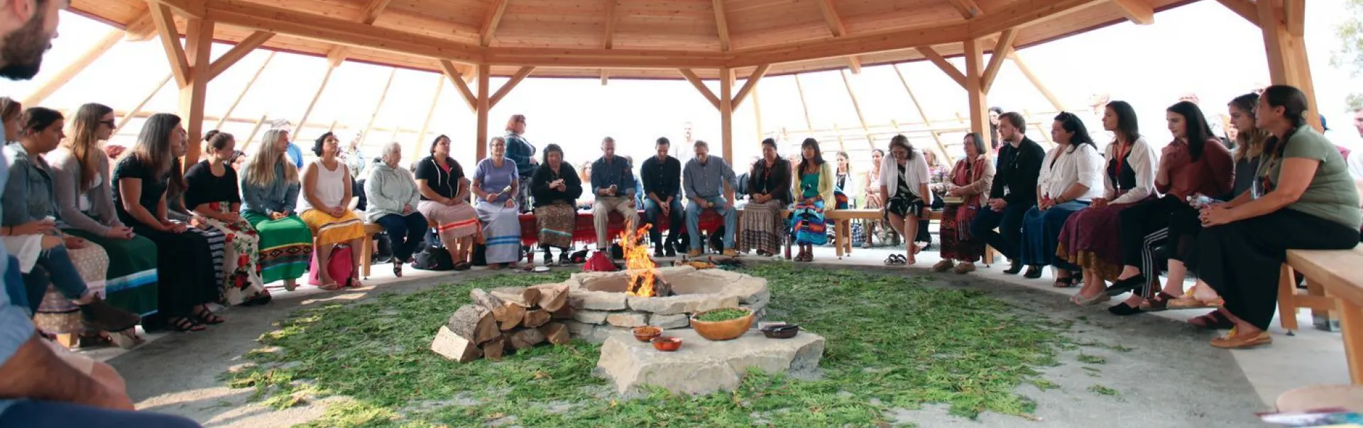 Indigenous event with people sitting around a fire