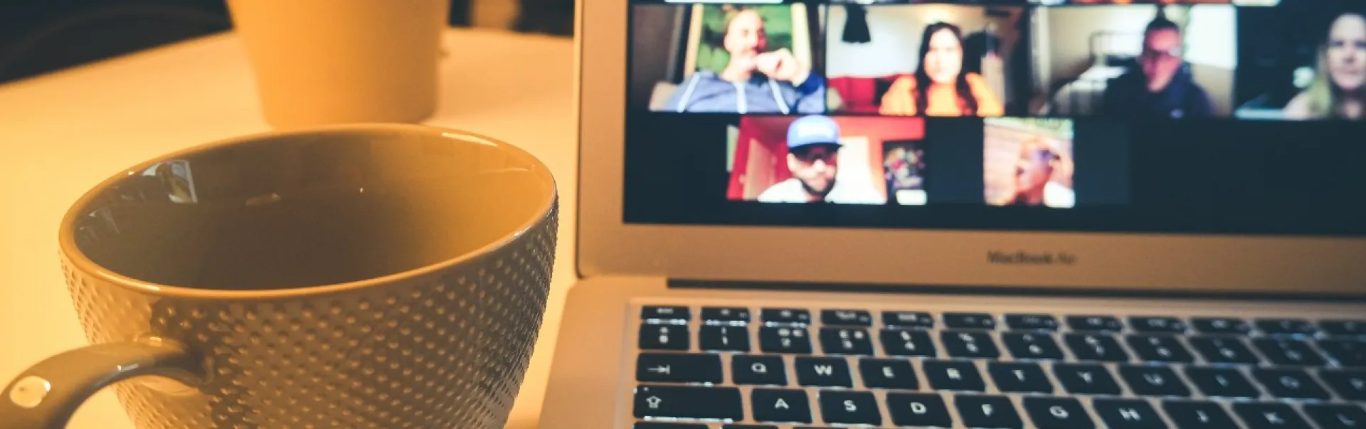Une tasse de café près d'un ordinateur portable sur un bureau 