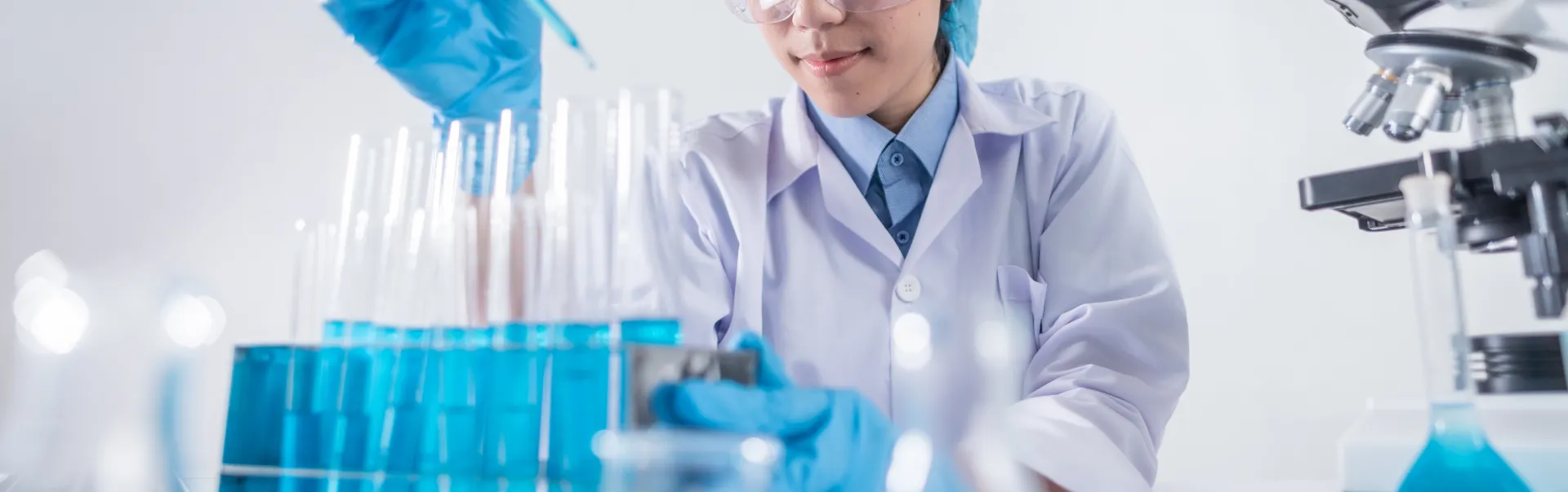 A student pipetting test tubes with a blue substance