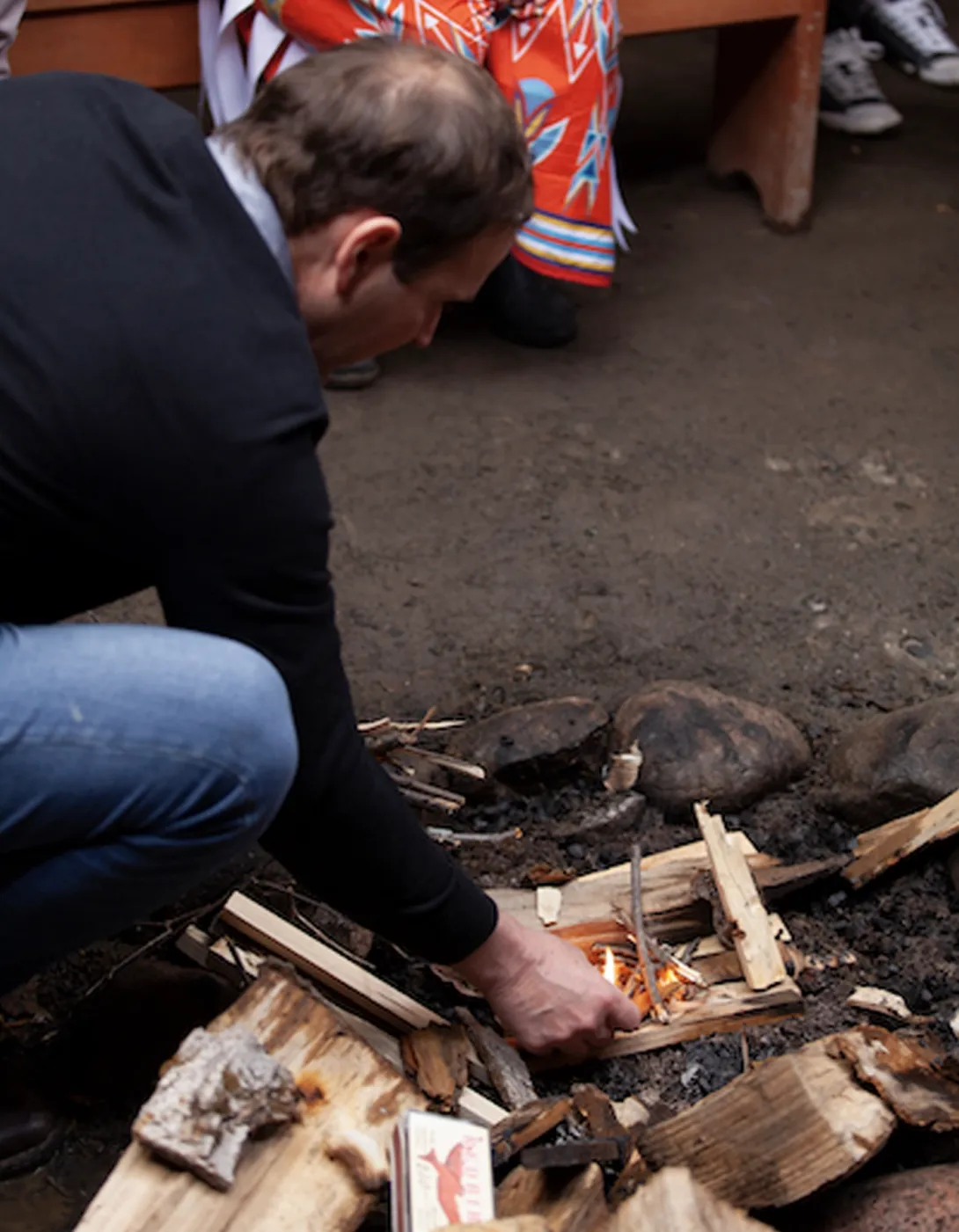 Dr. Kevin Fitzmaurice lights a campfire in the wigwam on campus.