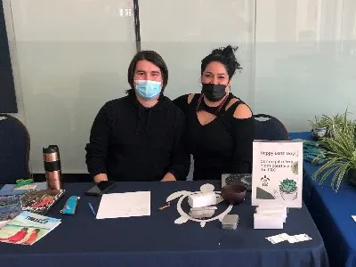 Bradleigh Trudeau sitting at a booth with his colleague.
