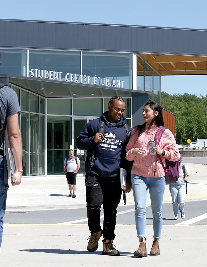 Students walking together from the SGA Student Centre building.