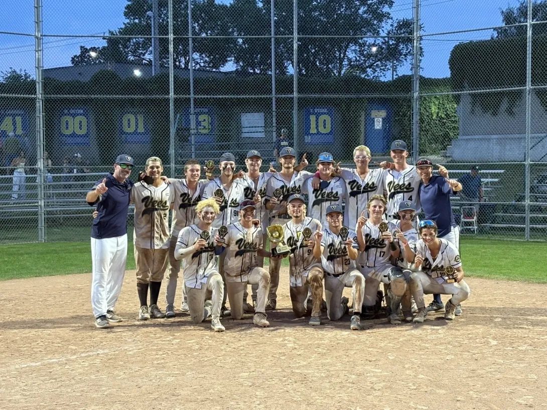 The Sudbury 18U baseball team celebrating on the field with their championship trophies.