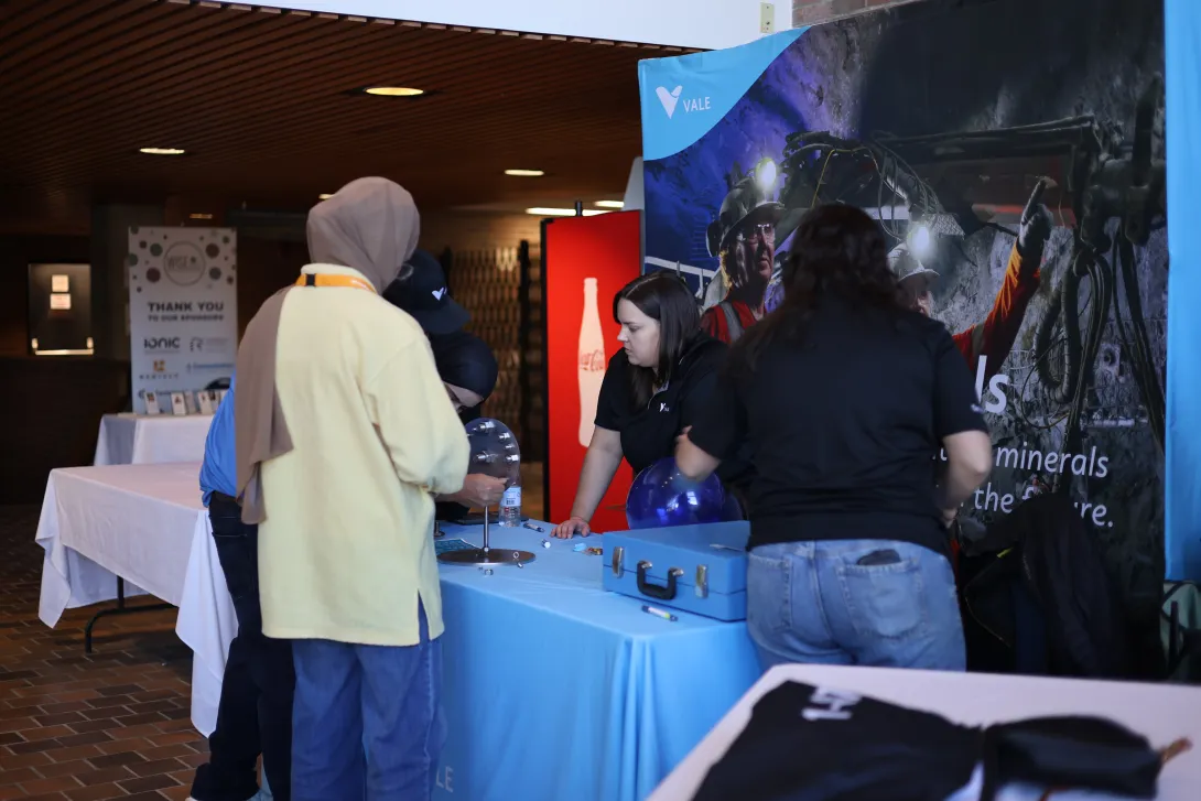 Students engage with company representatives at an interactive exhibit table hosted by Vale during the event.