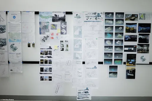 Architectural drawings, maps, photographs, and digital renderings displayed on a wall at the University of the Azores.